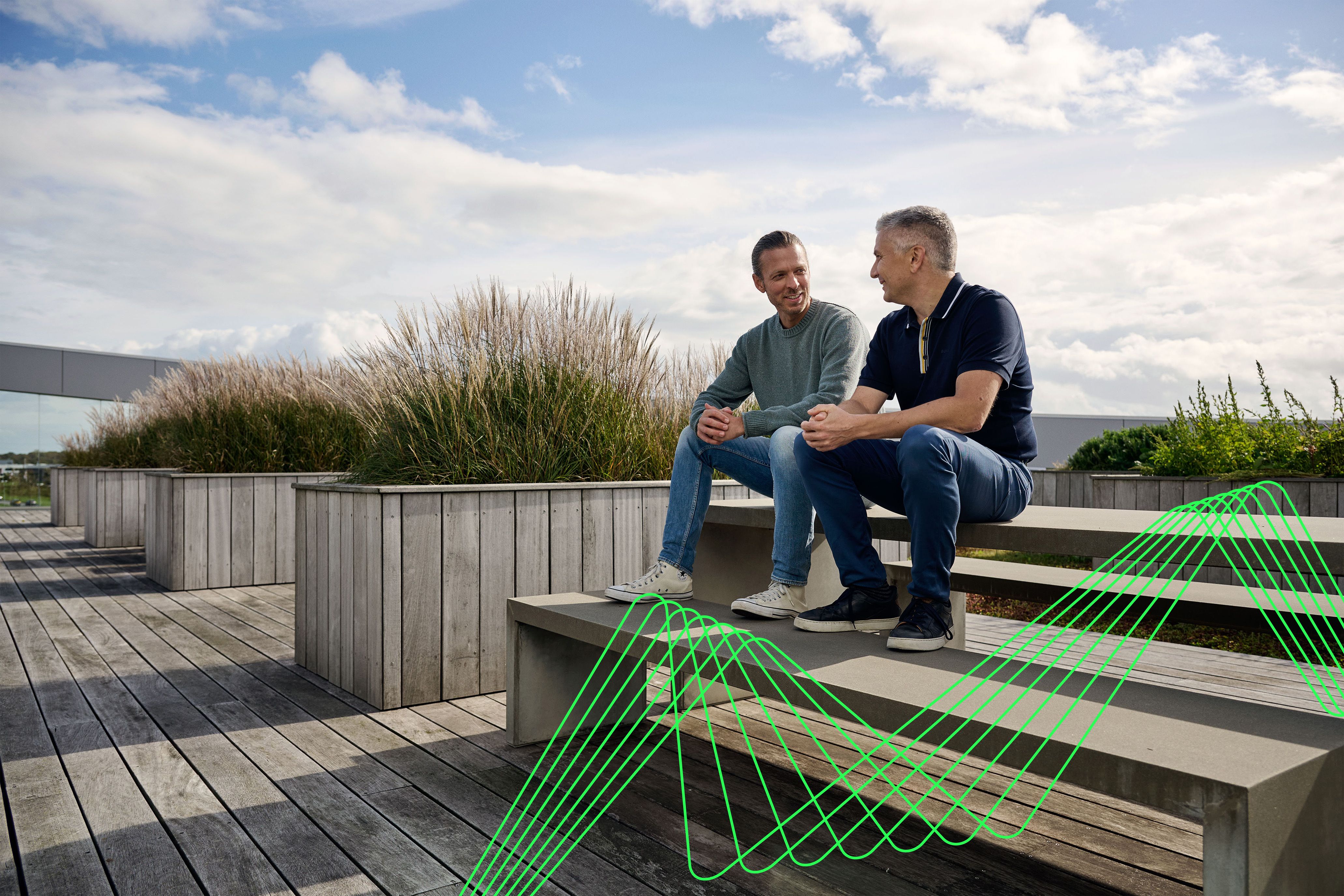 Kolleger på tagterrasse med elektriske bølger i grøn farve