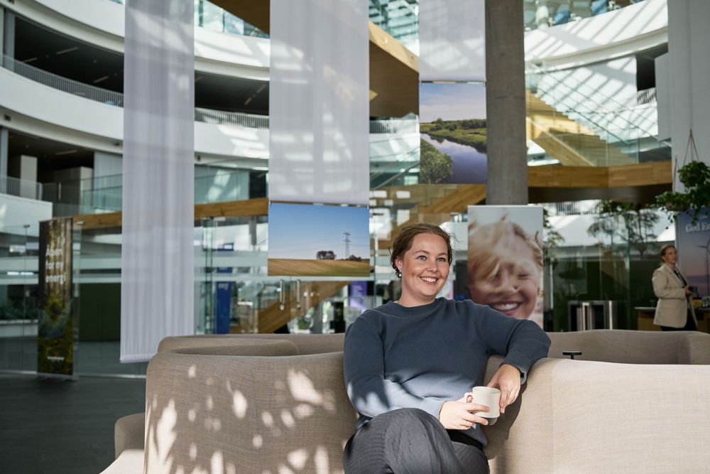 Kollega nyder en pause i sofaen med et smil på læben.