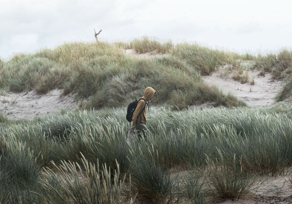 Person der går i diget på stranden