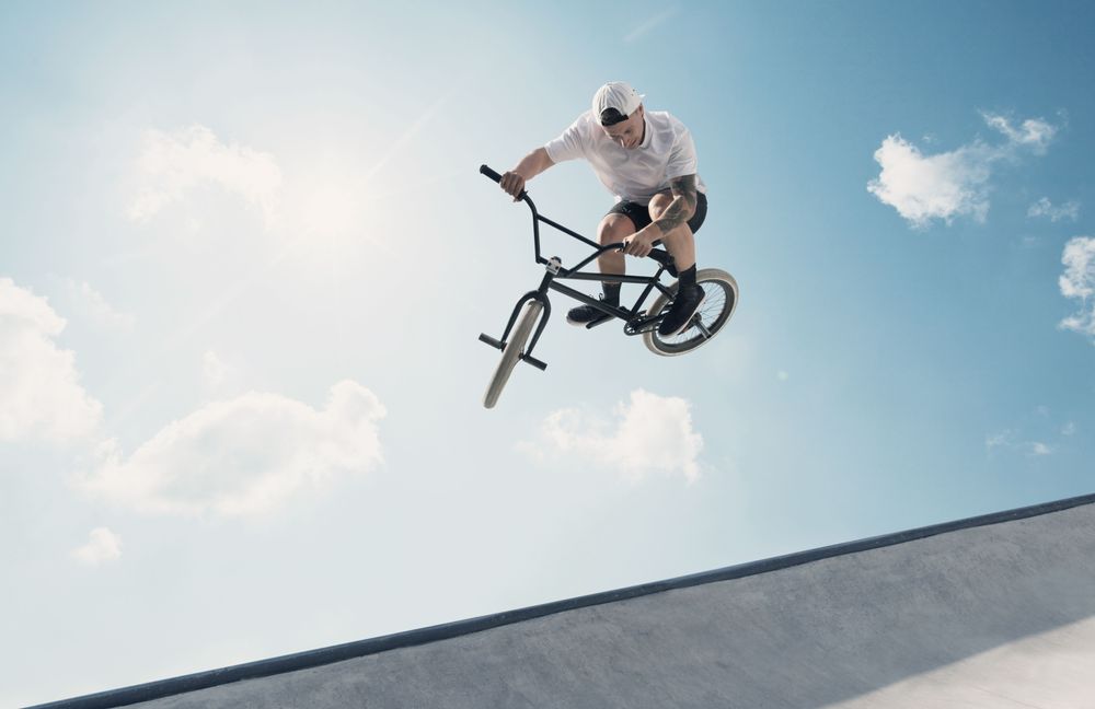 Ung mand i luften på en skaterampe med sin bmx cykel