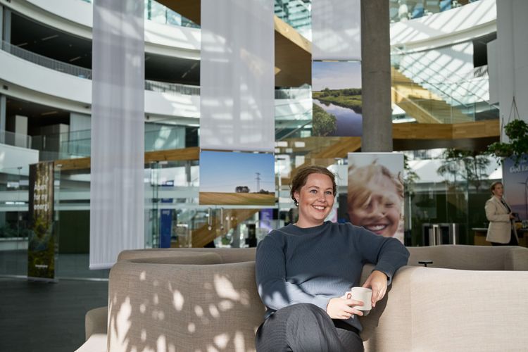 Kollega nyder en pause i sofaen med et smil på læben.