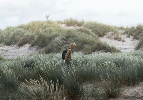 Person der går i diget på stranden 